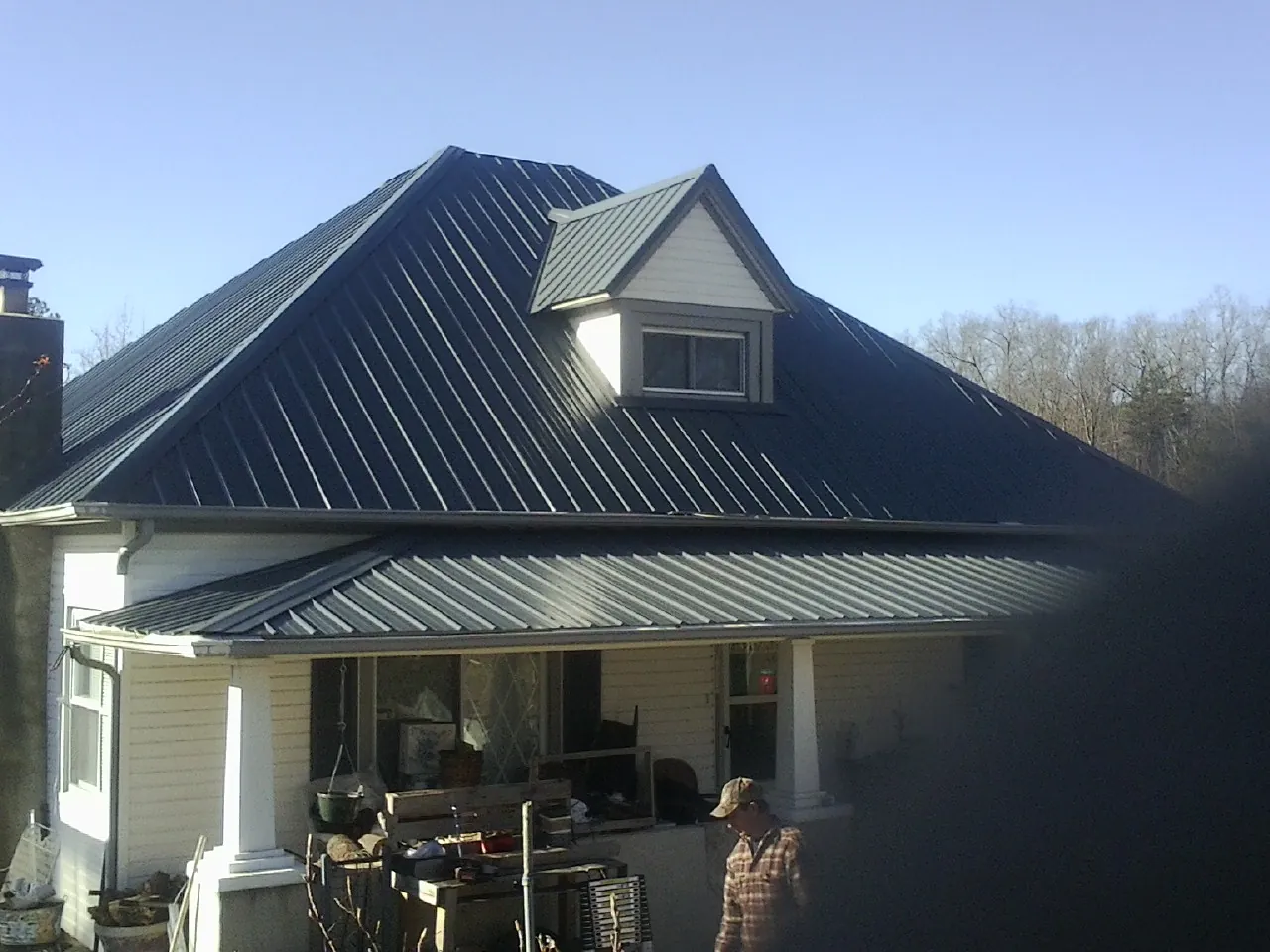Dark blue standing seam metal roof with a dormer above a front porch in Toledo