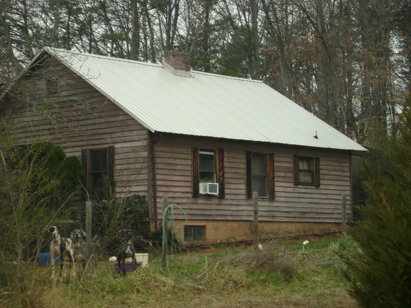White metal roof on an old wood sided farmhouse, from a Metal Roof Installation job in Toledo
